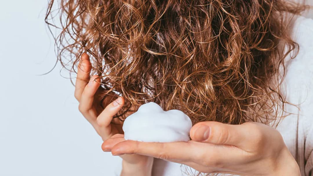 Jak wybrać piankę do stylizacji włosów kręconych, aby uniknąć puszenia?